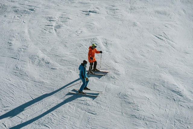 Skileraar legt een leerling de techniek uit op een piste in Baqueira