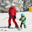 Kind leert skiën met een skileraar
